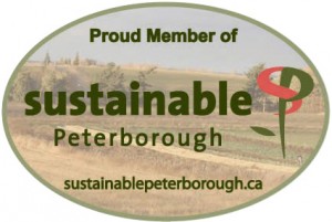 Proud Member of Sustainable Peterborough emblem showing the Sustainability Logo and farmland in the background