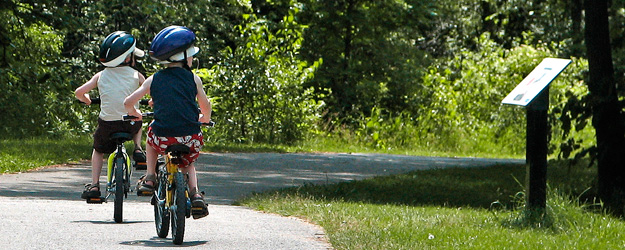 Children bike riding in a park in Peterborough, Ontario